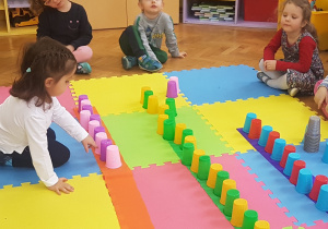 dzieci układają rytmy z kolorowych kubeczków